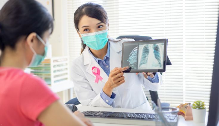 A doctor showing a patient an ultrasound of her breast.