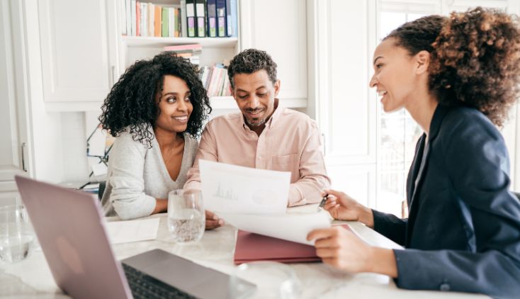A couple talking to a woman at a bank.
