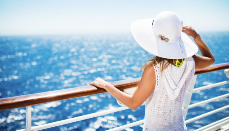 A woman looking out at the ocean from a cruise ship.