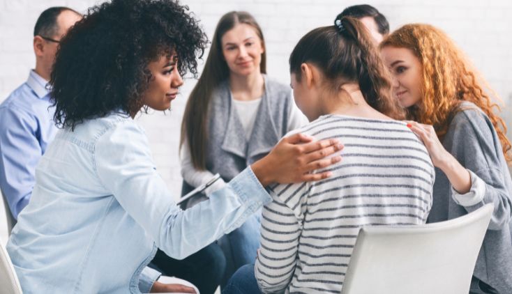 People sitting in a circle for a group therapy session.