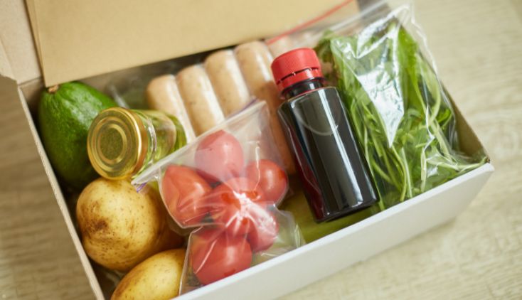 A meal kit box full of fresh produce.